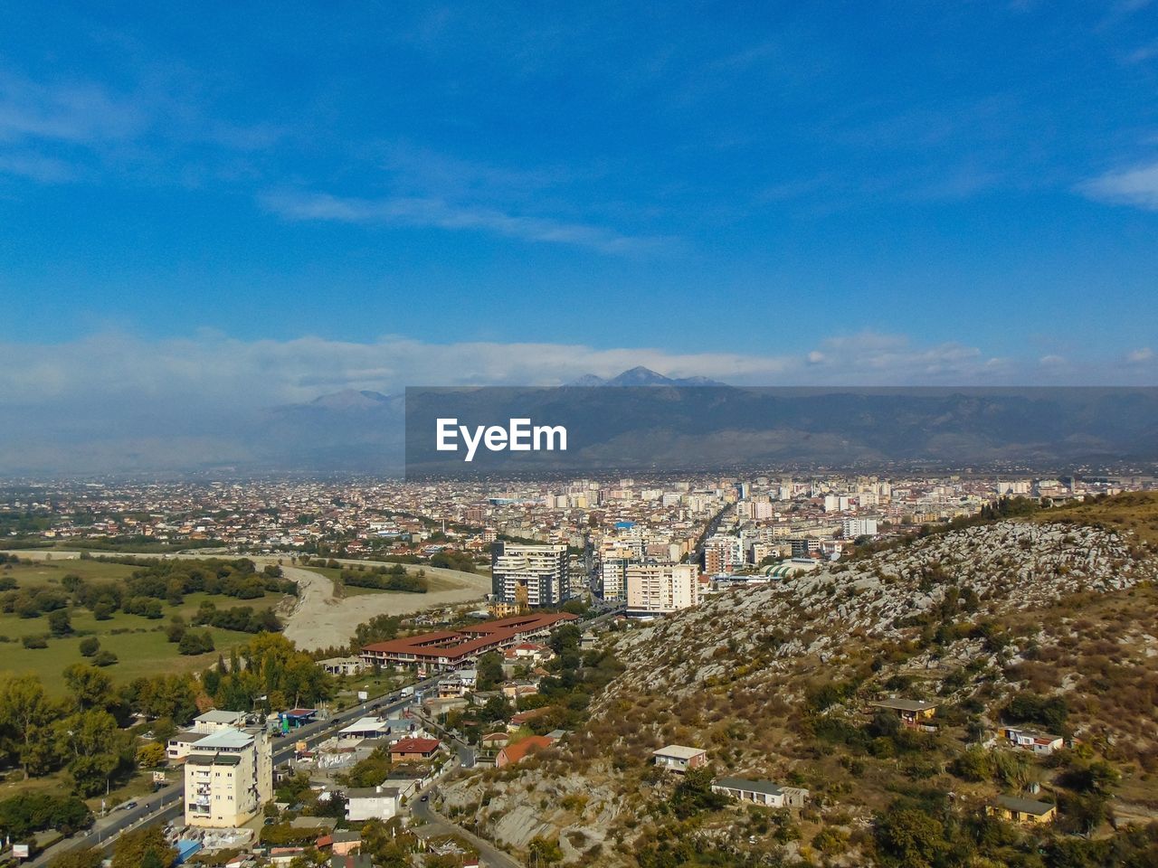 HIGH ANGLE VIEW OF BUILDINGS AGAINST BLUE SKY