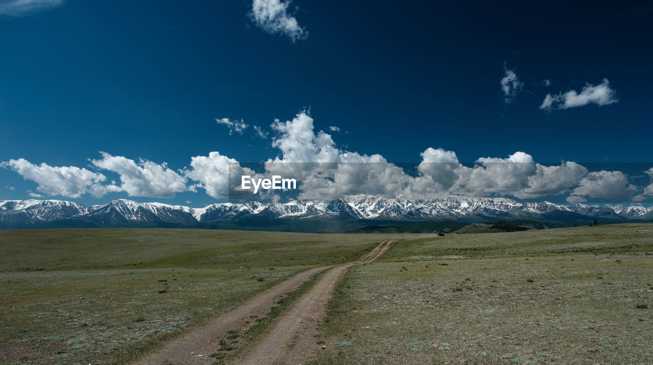 SCENIC VIEW OF ROAD BY MOUNTAINS AGAINST SKY