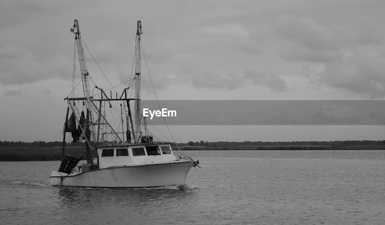 Black and white photo of a fishing boat heading out of apalachicola bay in apalachicola, florida, us