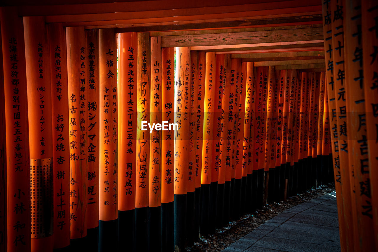 ILLUMINATED TEXT BY BUILDING AGAINST ORANGE SKY