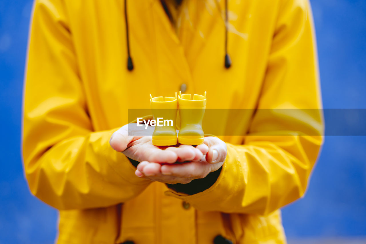 Midsection of woman holding toy boots