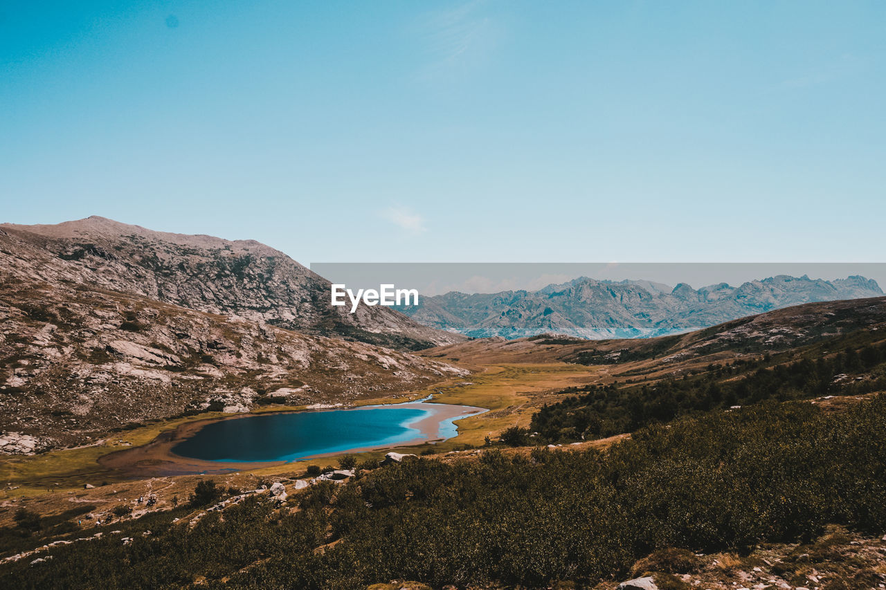 Scenic view of mountains against blue sky