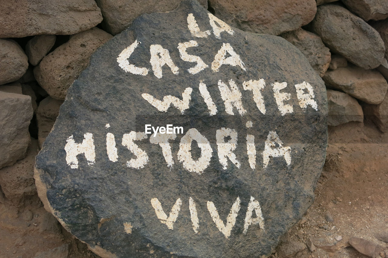 HIGH ANGLE VIEW OF TEXT ON STONE WALL