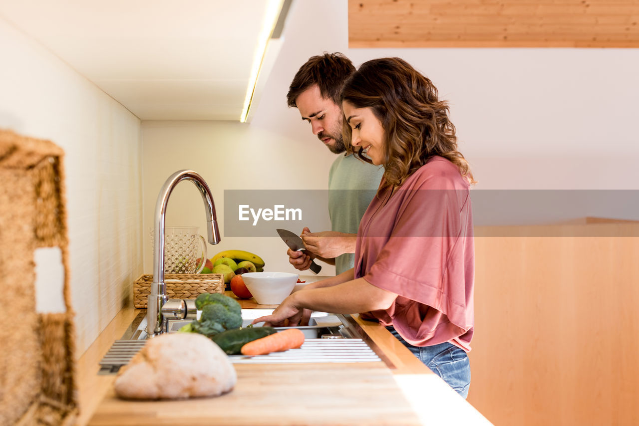 Couple preparing food together in kitchen at home