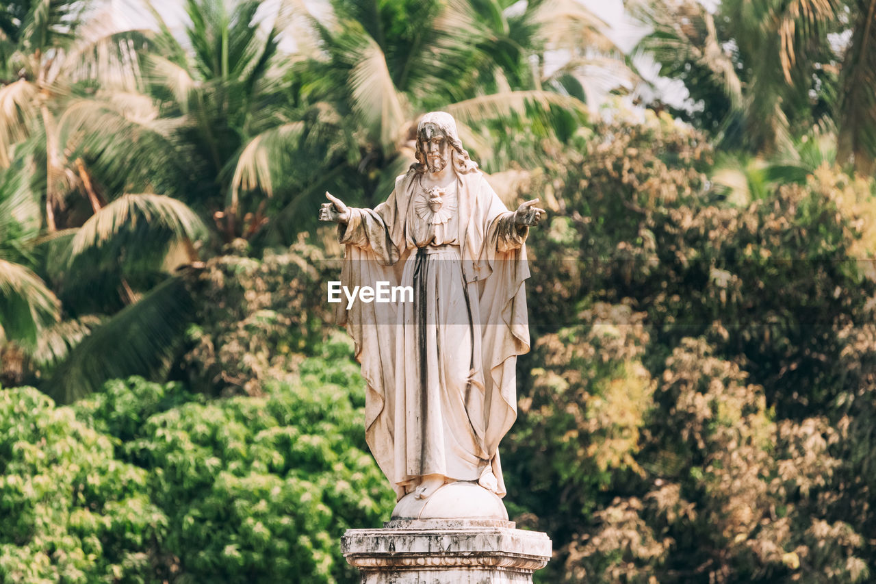 STATUE OF ANGEL AGAINST TREES