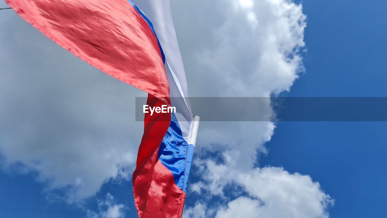 low angle view of flag against cloudy sky