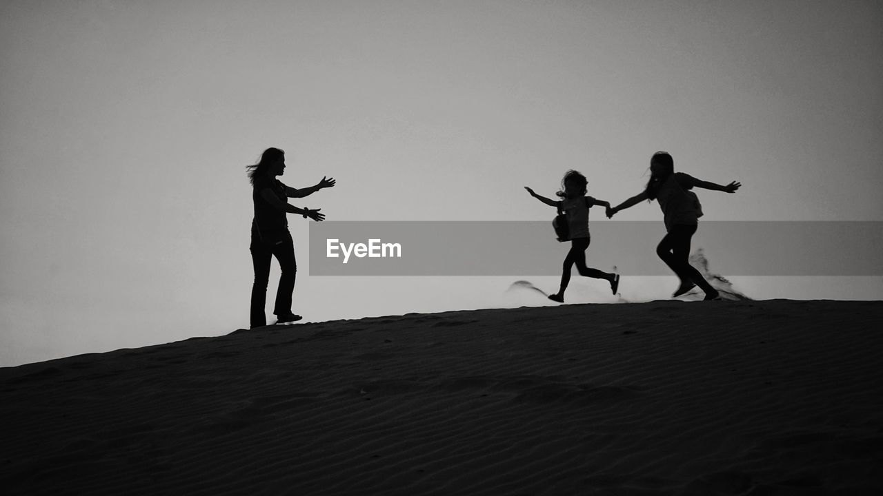 SILHOUETTE PEOPLE STANDING ON LAND