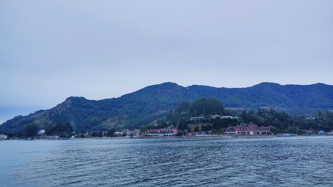 SCENIC VIEW OF SEA AND TOWN AGAINST CLEAR SKY