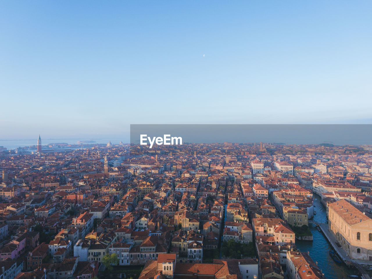 Aerial view of cityscape against blue sky