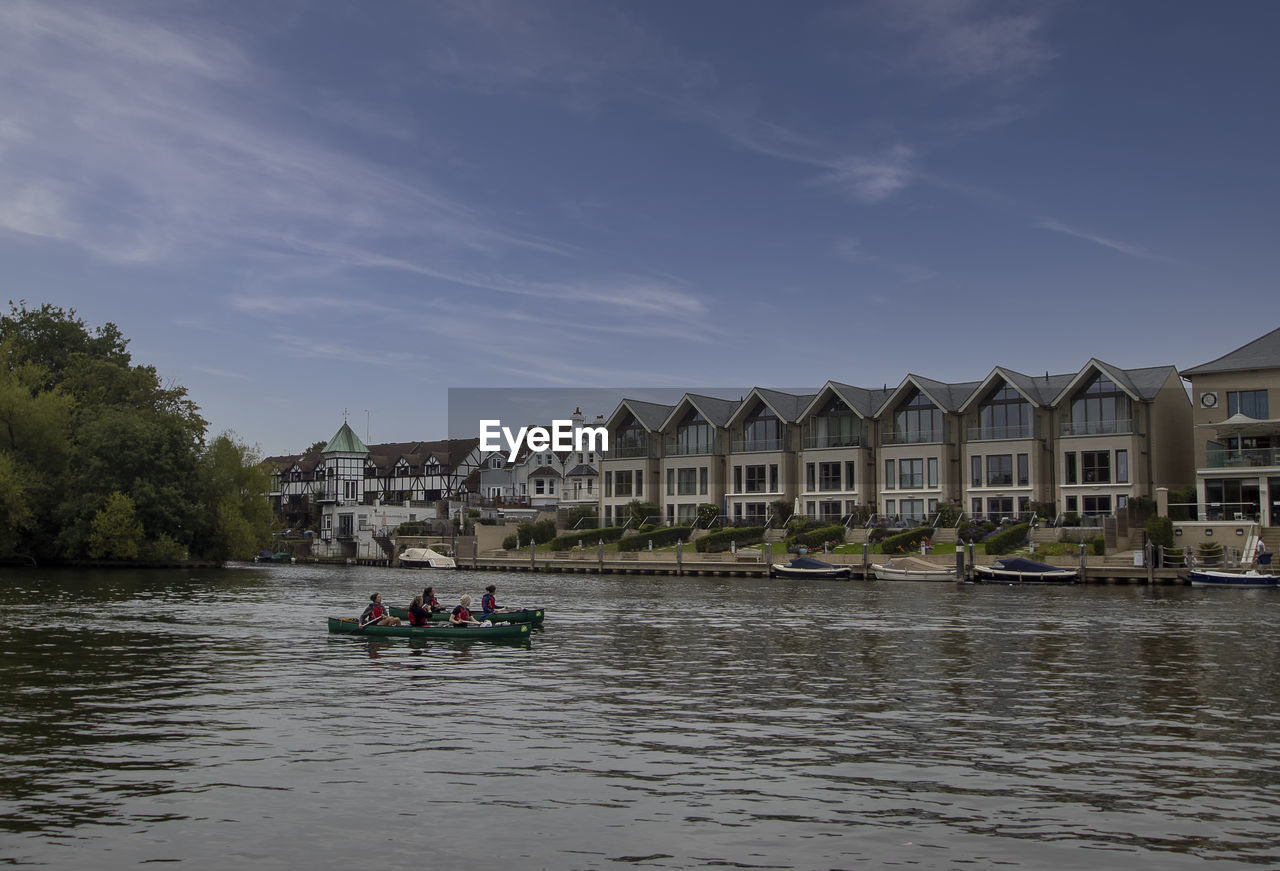 PEOPLE ON RIVER AGAINST BUILDINGS