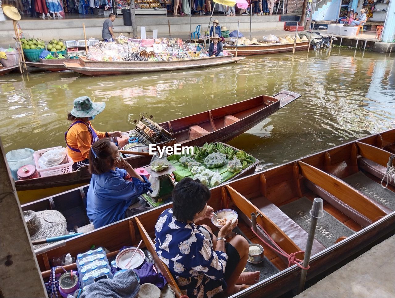 nautical vessel, water, transportation, men, group of people, mode of transportation, adult, boat, vehicle, boating, high angle view, occupation, women, sitting, food and drink, market, business, food, watercraft, day, nature, person, lifestyles, travel, hat, architecture, river, selling, clothing, small business, retail, outdoors, working, casual clothing, crowd, large group of people, rowing, fishing