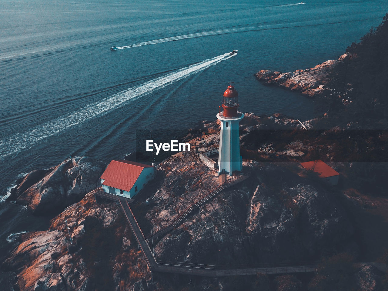 High angle view of lighthouse by sea and buildings
