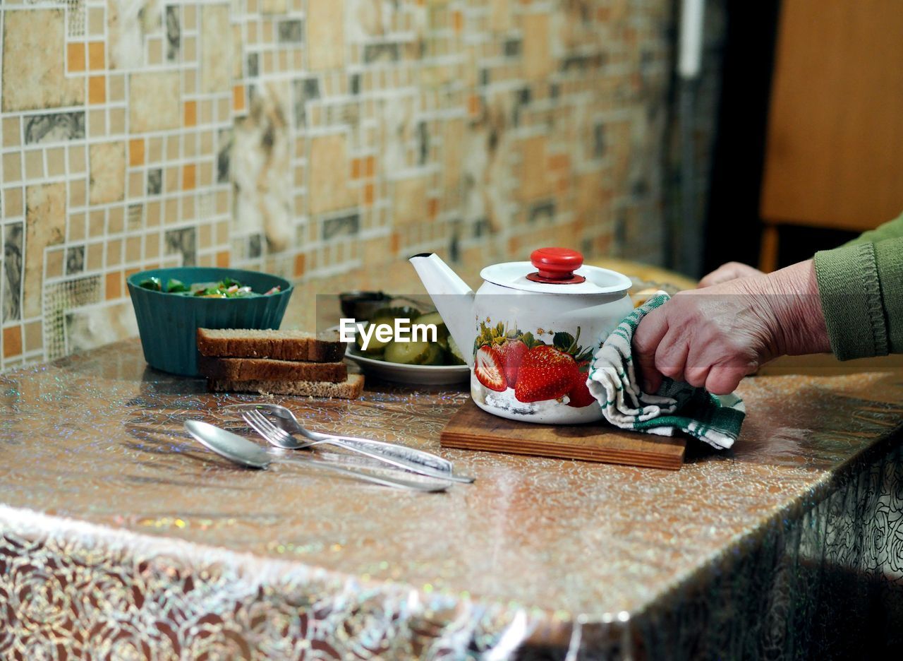 midsection of woman holding coffee on table