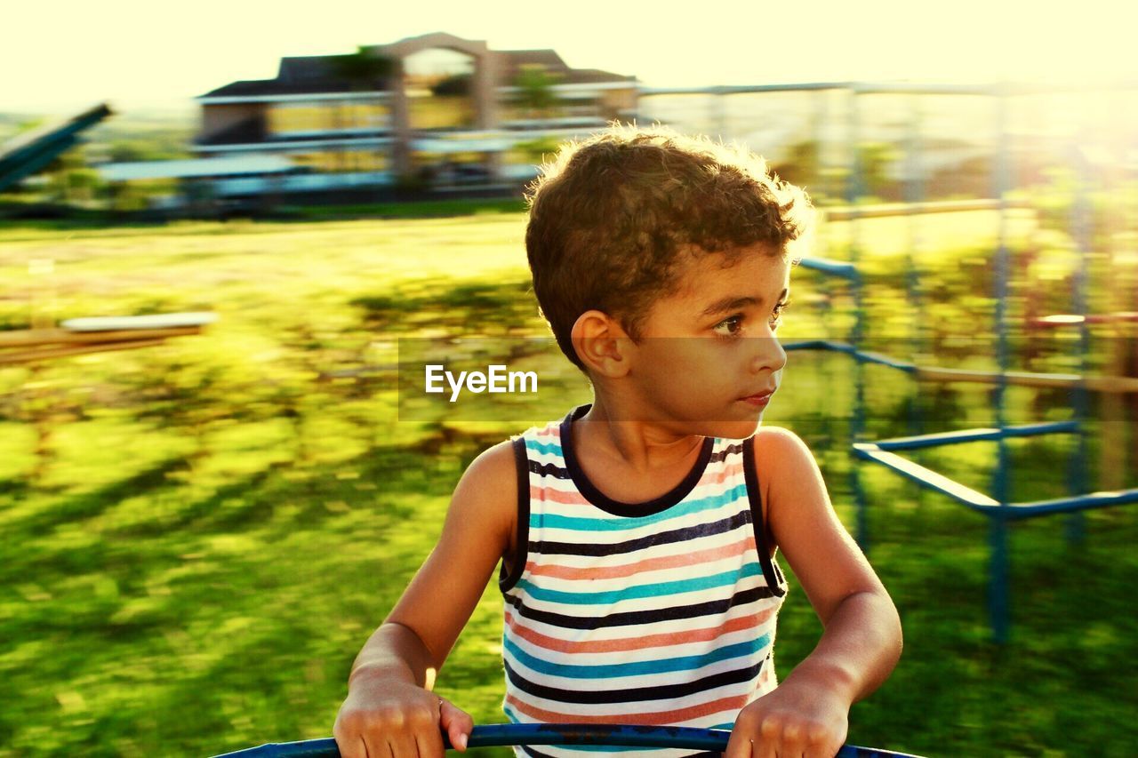 Boy playing with outdoor play equipment in park