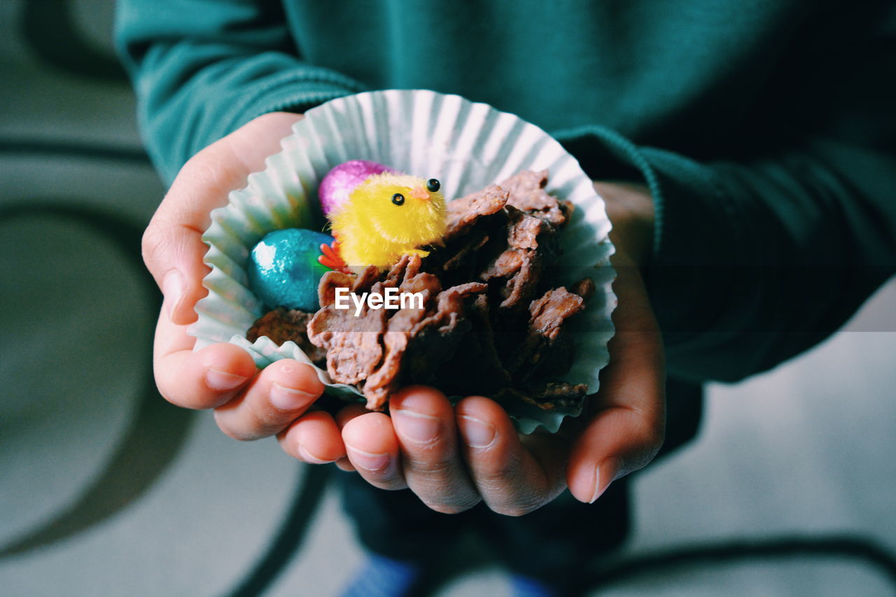 Close-up of boy holding easter chocolates in hand