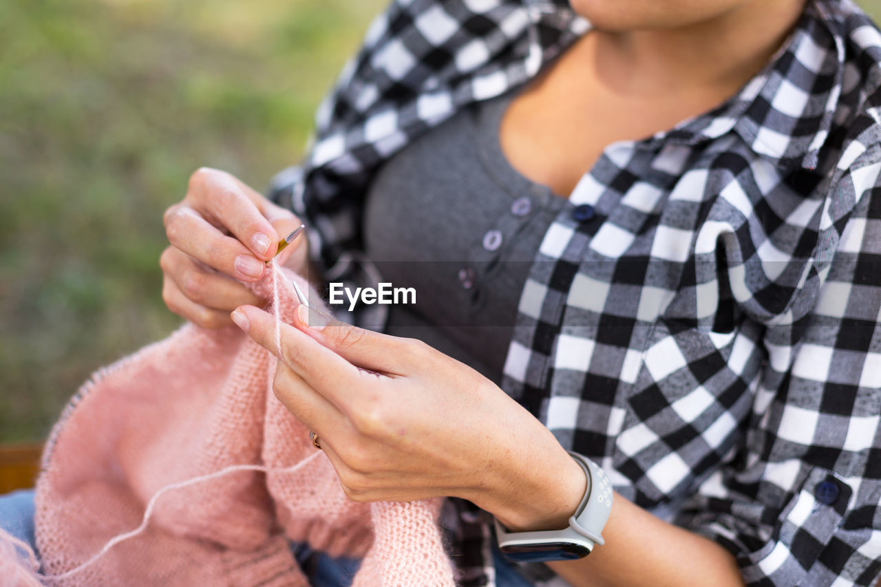 Midsection of woman knitting