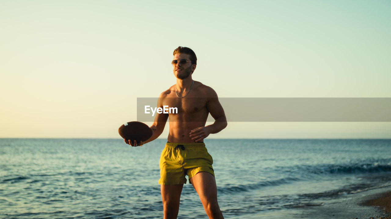 Boy plays football at the sea