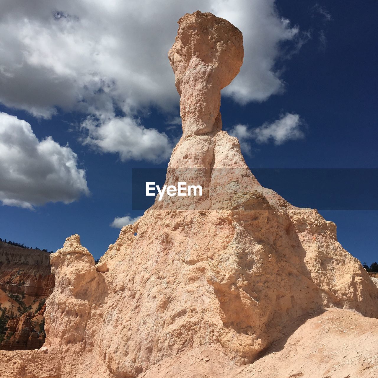 Low angle view of rocks against cloudy sky