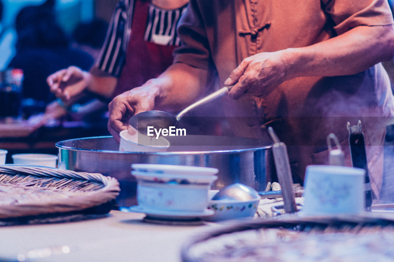 Midsection of chef working in commercial kitchen