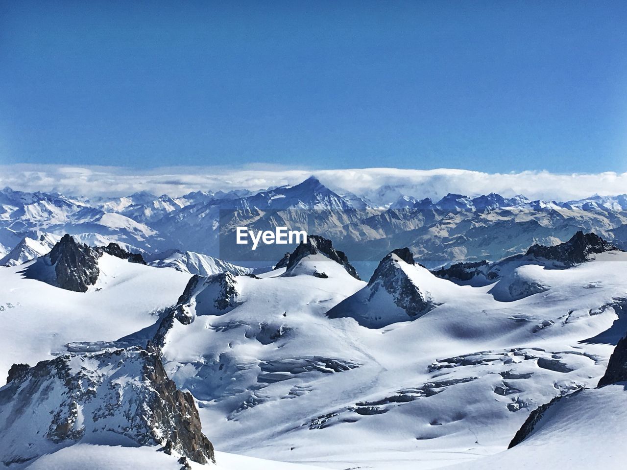 SNOWCAPPED MOUNTAINS AGAINST BLUE SKY