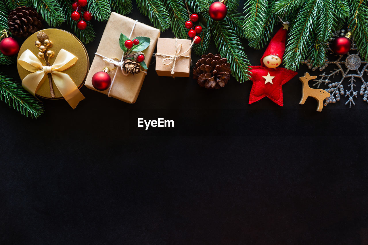 Holiday christmas with decoration ball, stars,snowflakes, gift box, pine cones on a black background