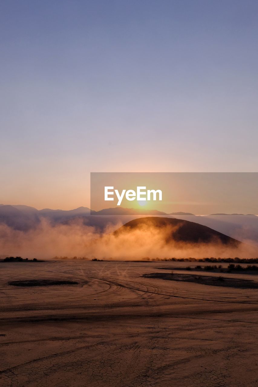 Scenic view of desert against sky during sunset