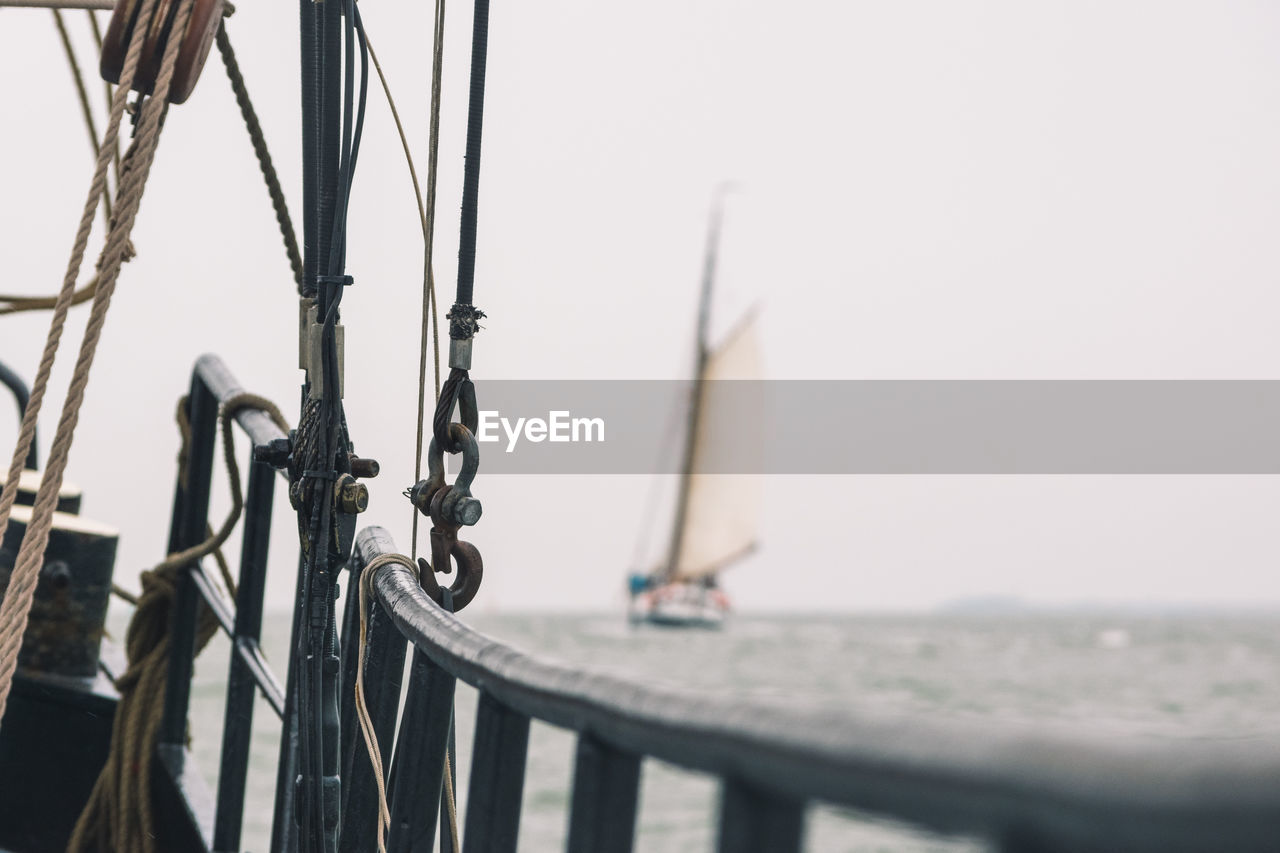 Close-up of railing on a sailboat - ship sailing on ocean in backgroundbackground- selective focus