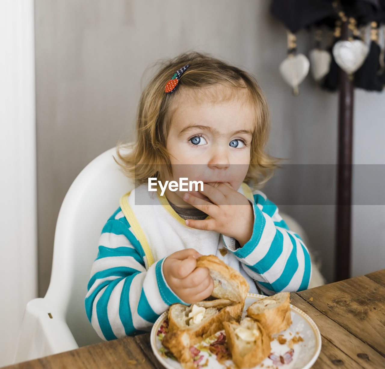 Portrait of baby girl eating food while sitting at table