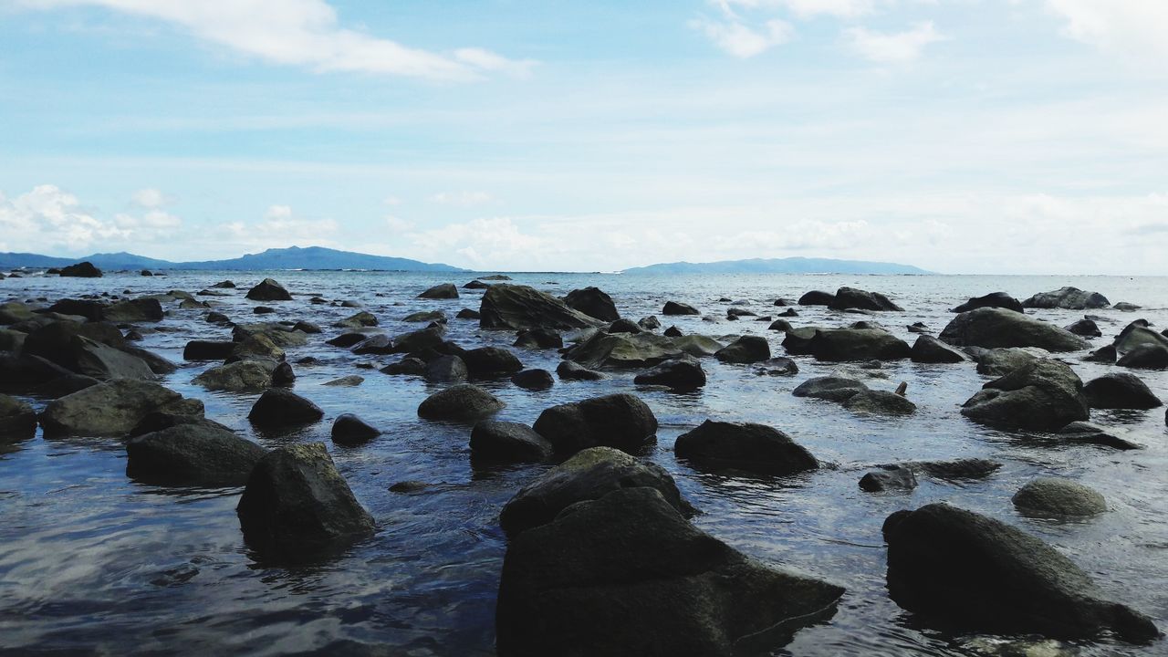 ROCKS IN SEA AGAINST SKY