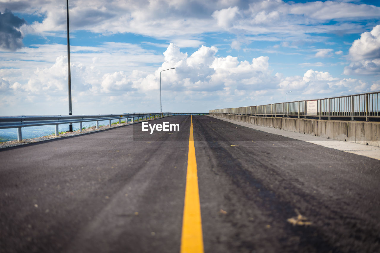 Empty road against cloudy sky