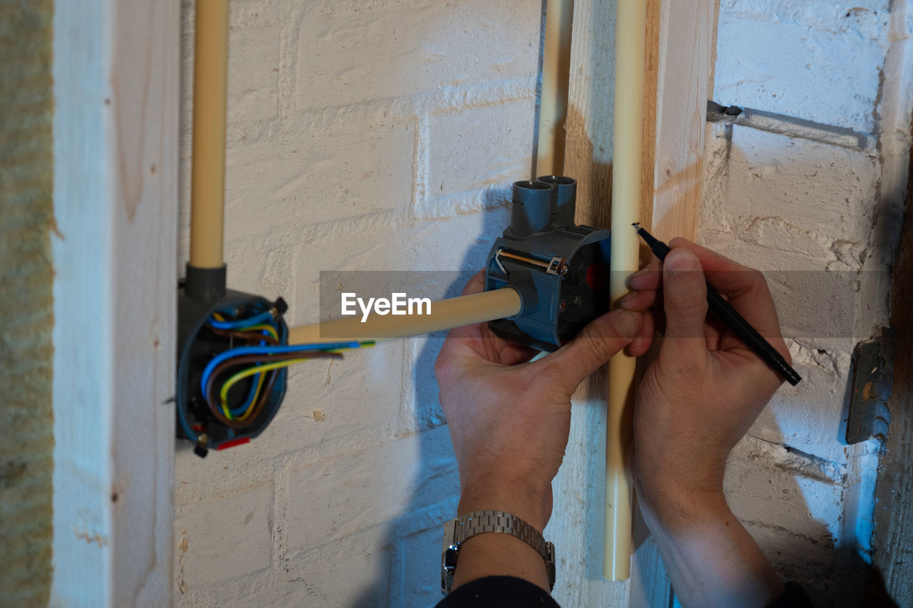 Installing electrical wiring with the brown phase, the blue neutral and the yellow earth wire 