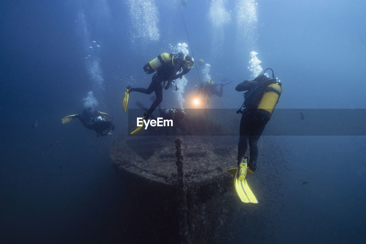 Men and women examining el naranjito sunken ship undersea
