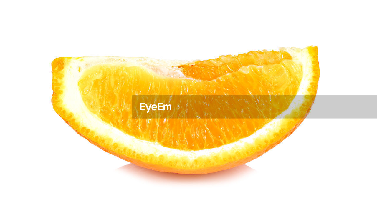 CLOSE-UP OF ORANGE SLICE OVER WHITE BACKGROUND