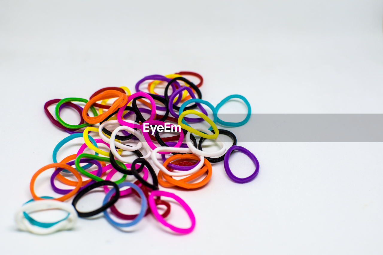 High angle view of multi colored rubber band on white background