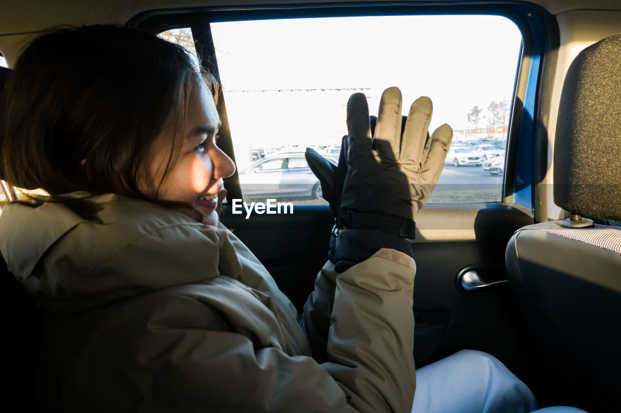 Side view of young woman sitting in car