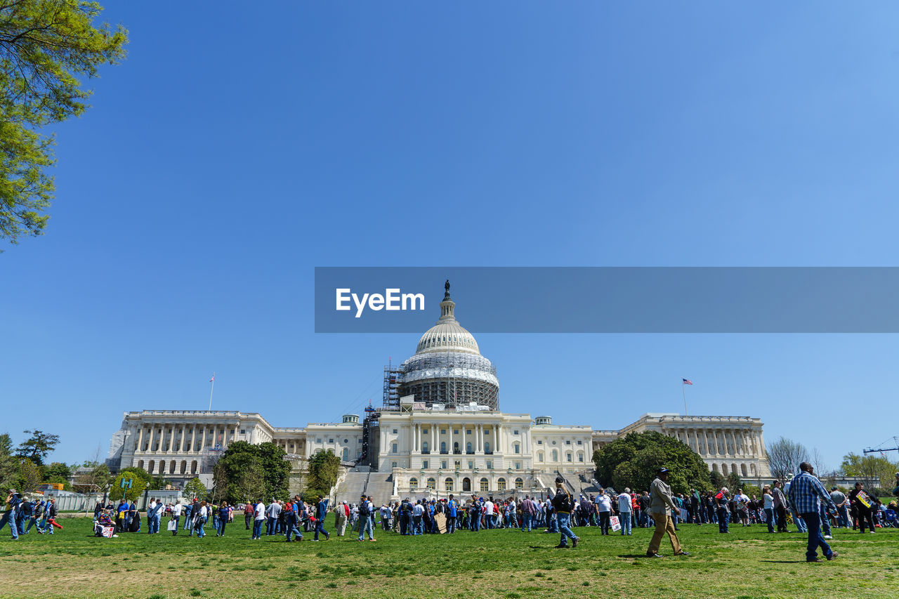 Tourists in front of capitol hill against clear sky