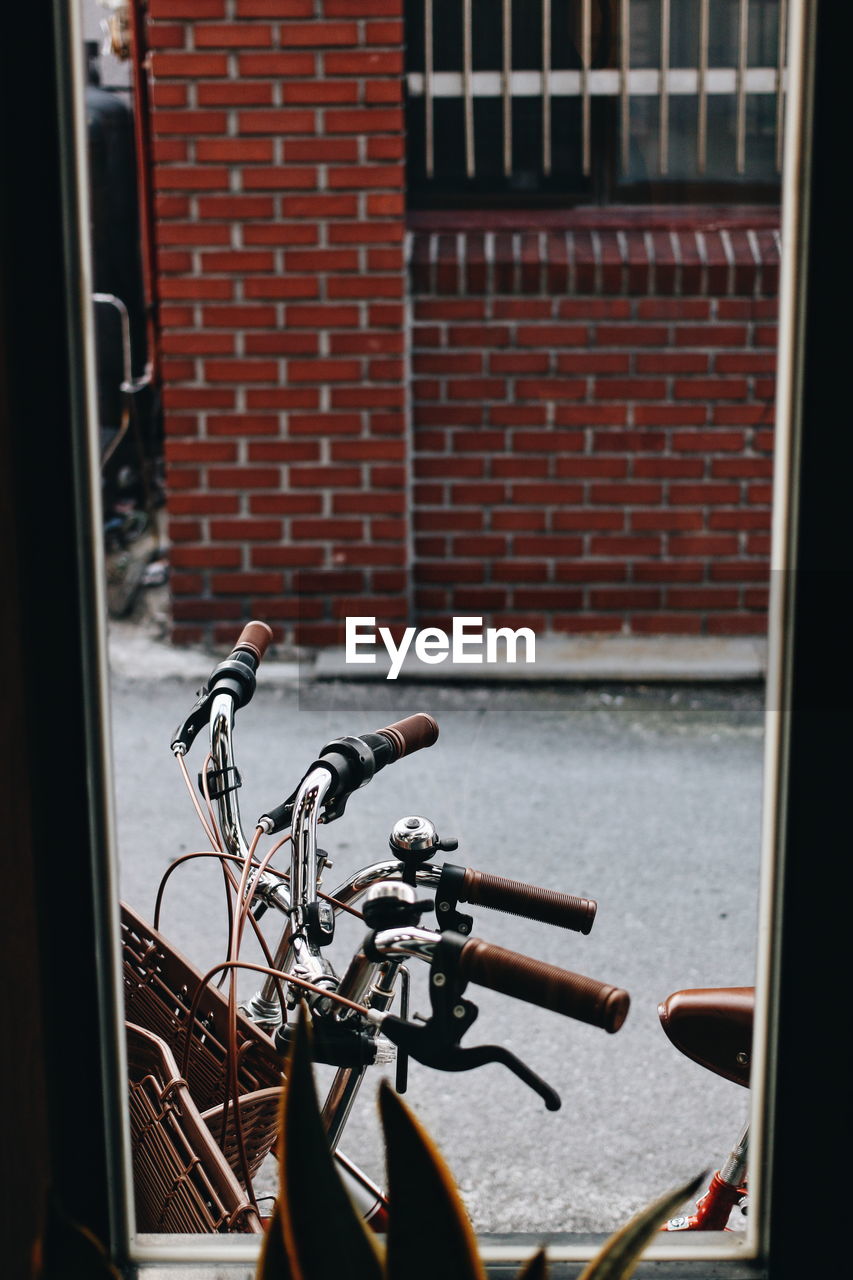 Bicycle parked against brick wall