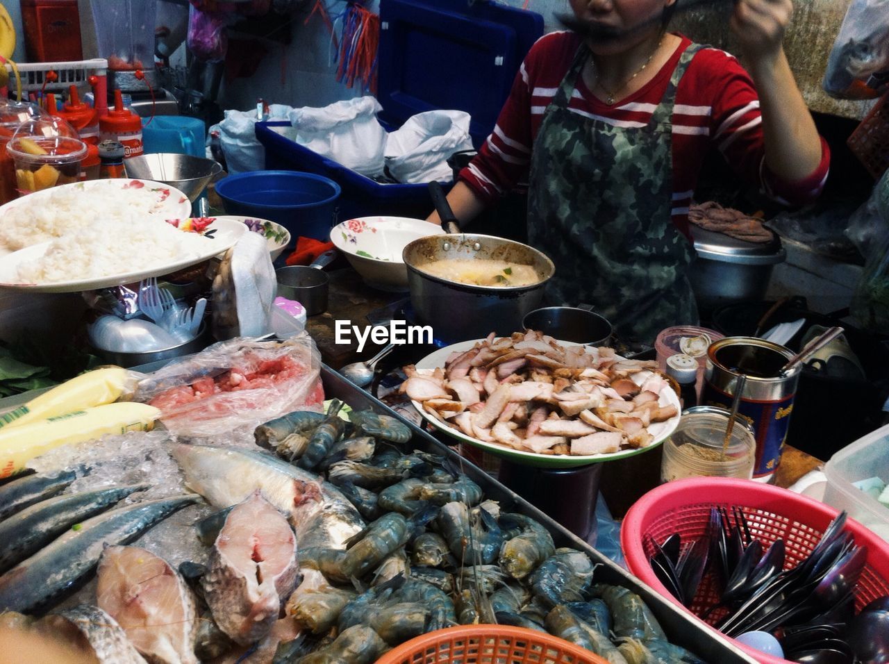 Midsection of woman cooking food in street market stall