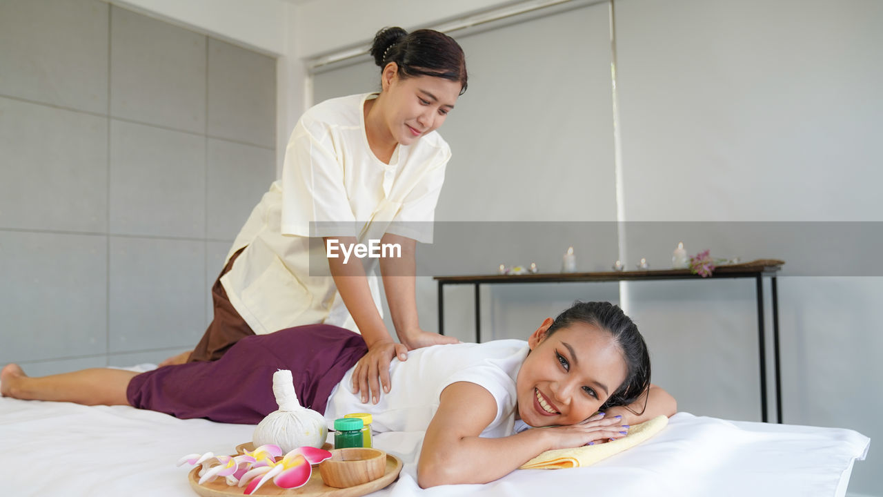 Spa massage, thai spa masseuse doing female massage in spa salon