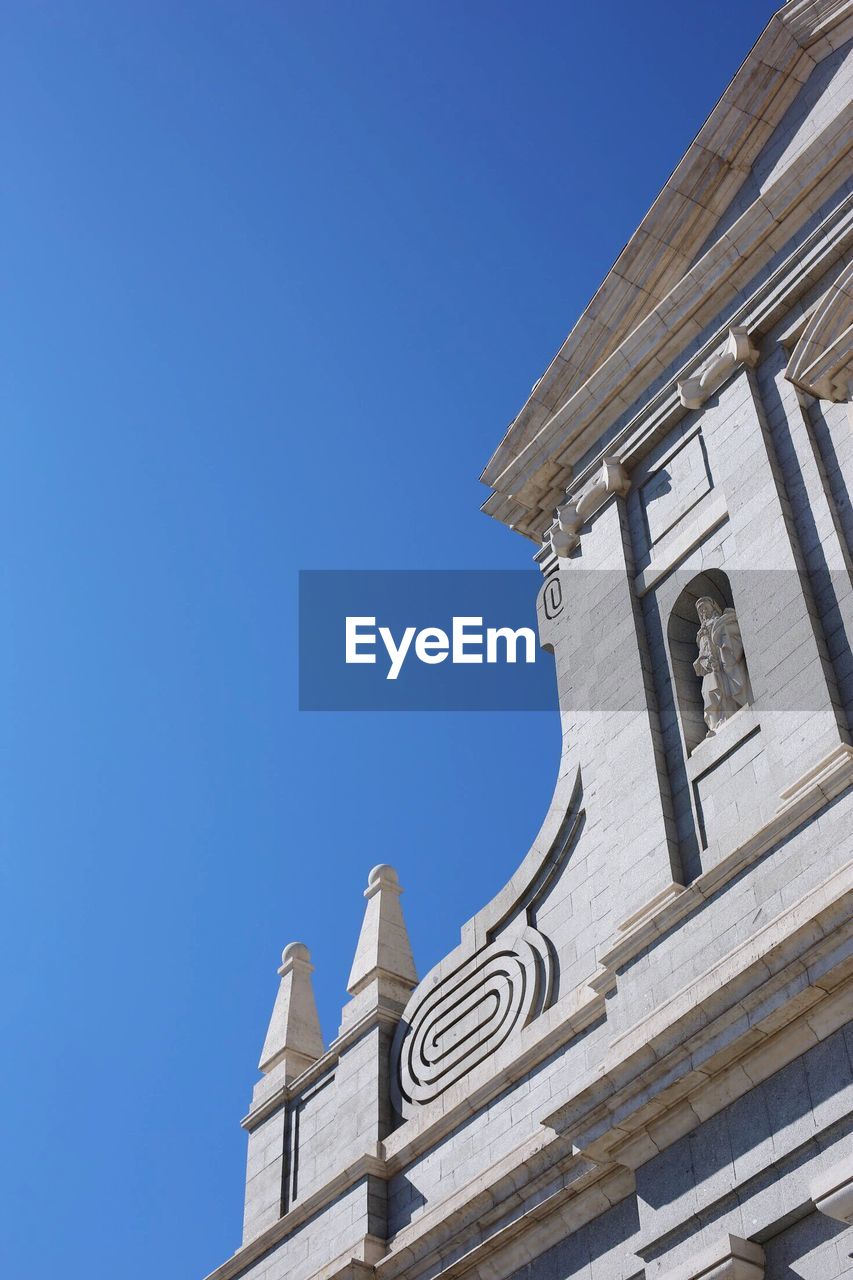 LOW ANGLE VIEW OF BUILDING AGAINST BLUE SKY