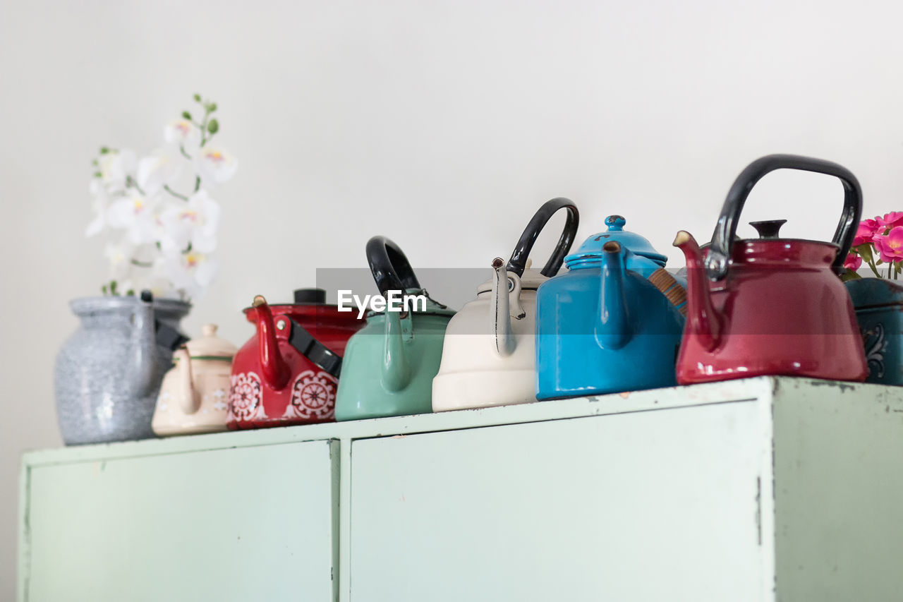 Close-up of multi colored kettles on shelf