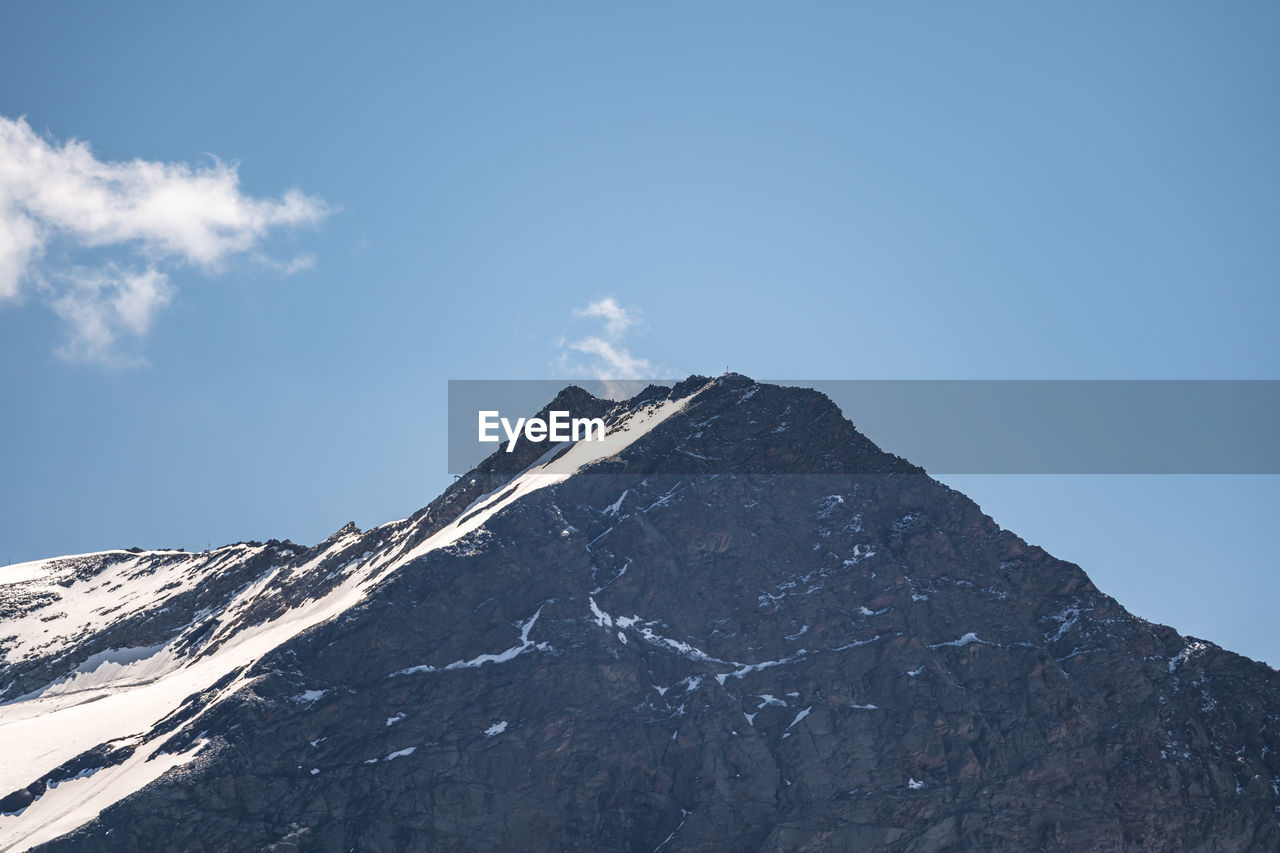 LOW ANGLE VIEW OF SNOW COVERED MOUNTAIN AGAINST SKY