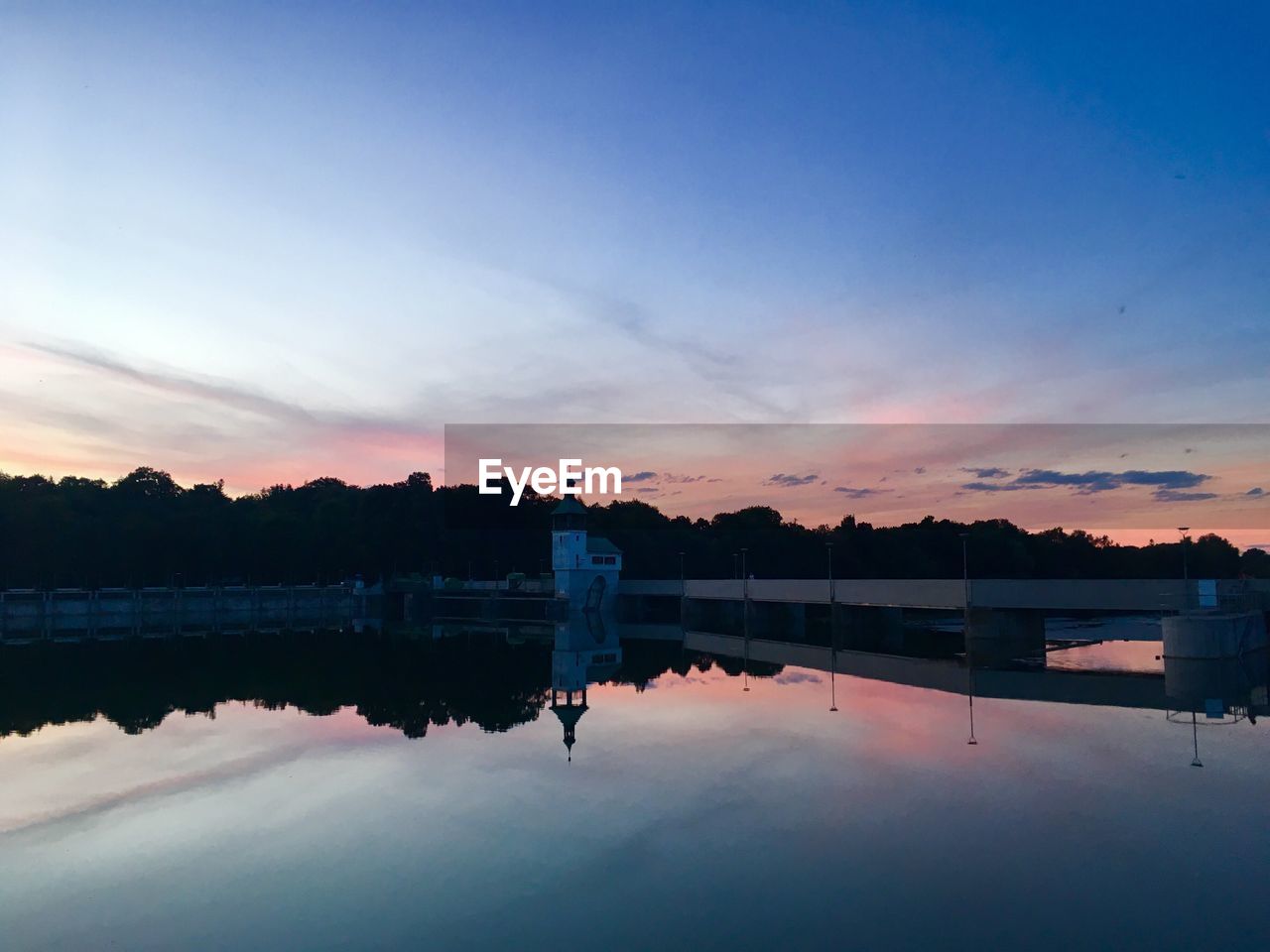 REFLECTION OF SILHOUETTE MAN IN LAKE AGAINST SKY DURING SUNSET