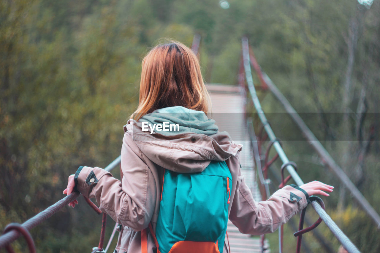 Rear view of woman standing on footbridge