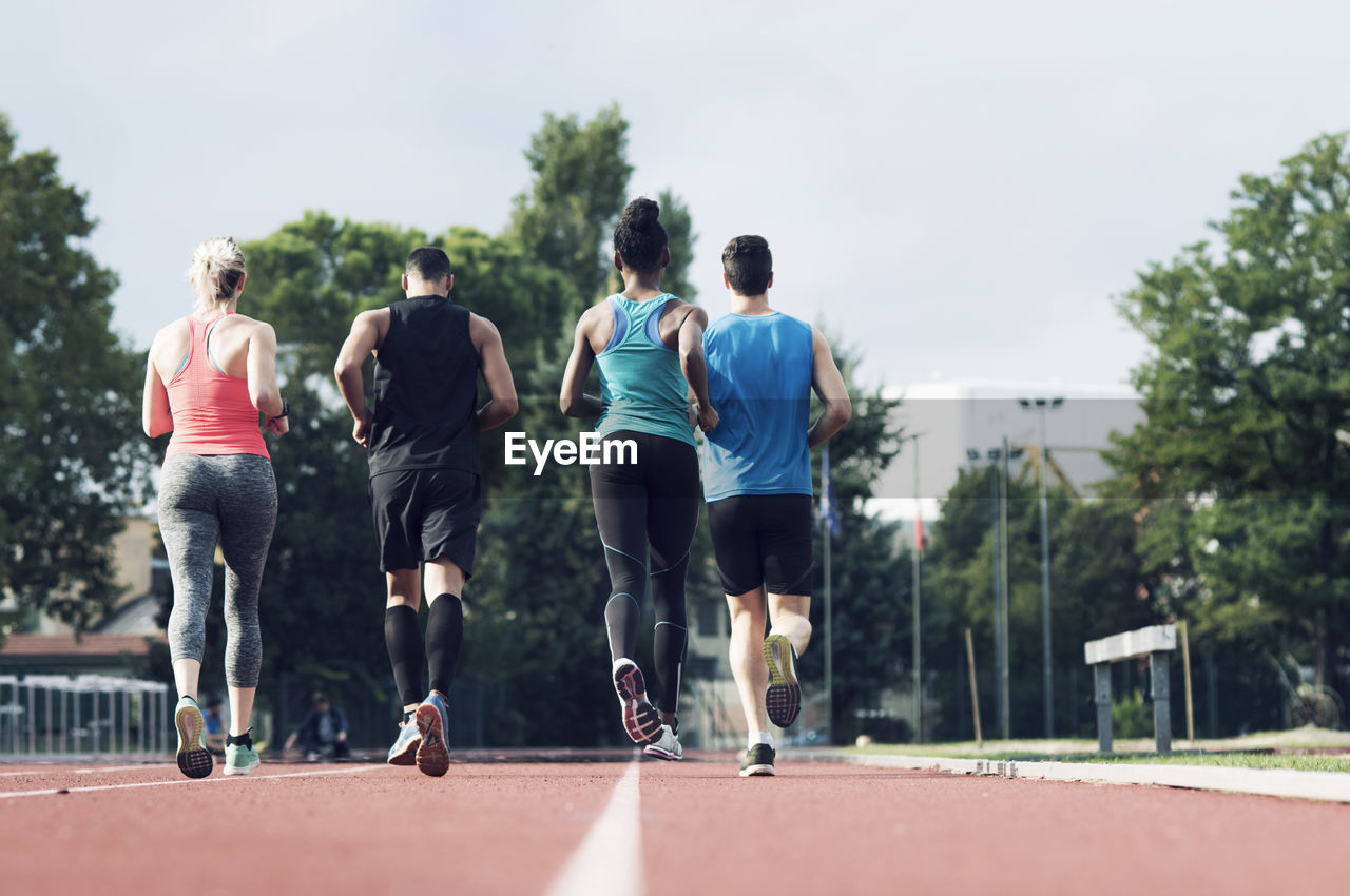 Rear view of athletes running on track