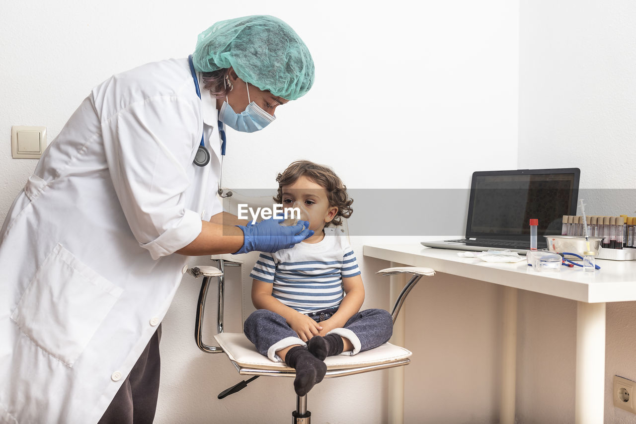 Female doctor examining kid little child boy.