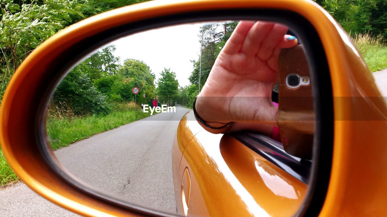 Reflection of hand on rear view mirror