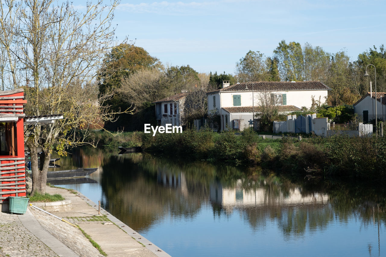 architecture, water, built structure, building exterior, building, tree, house, reflection, plant, nature, waterway, residential district, lake, sky, no people, outdoors, body of water, day, home, transport, rural area, city