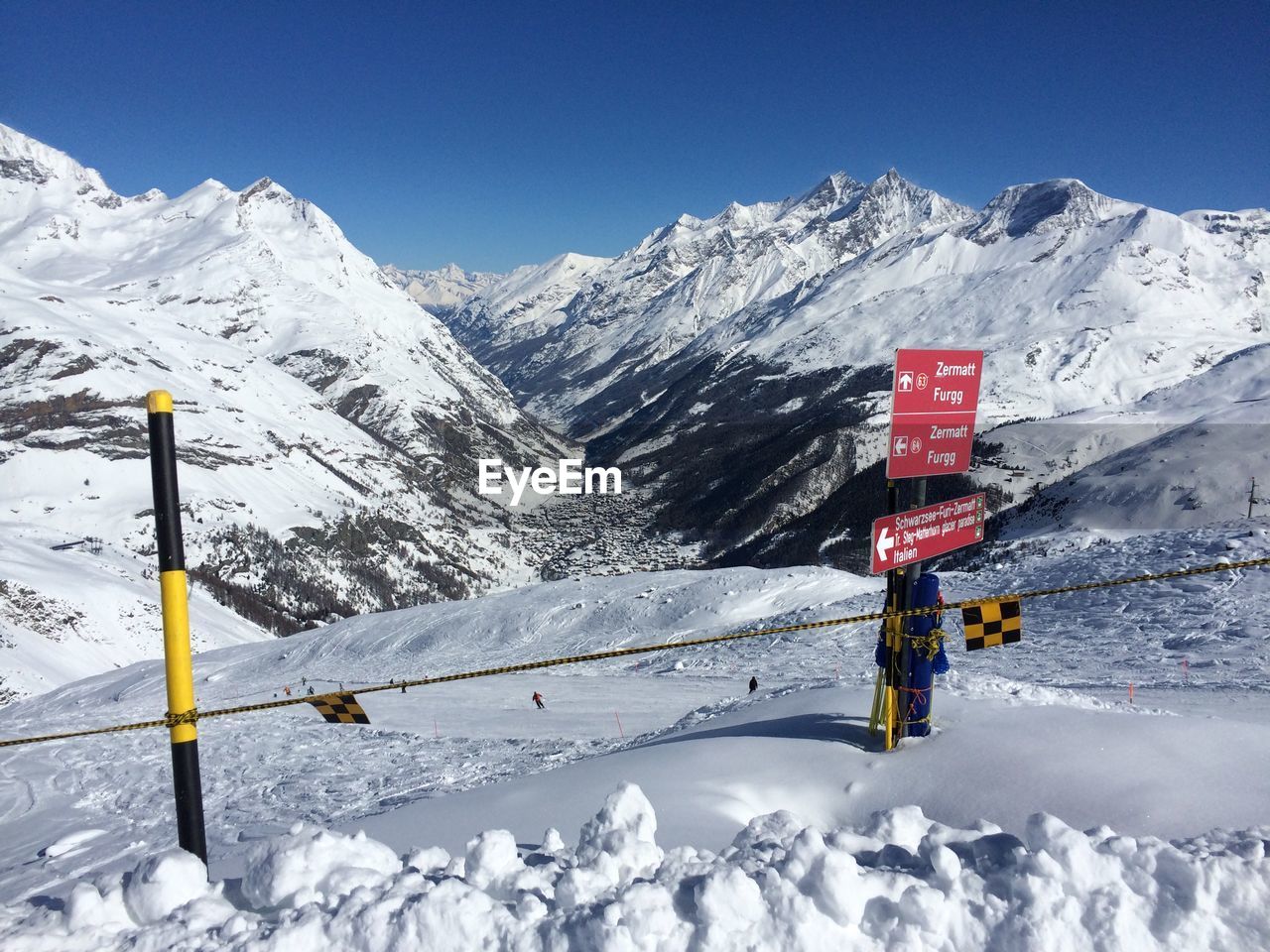 Directional sign on snowcapped mountain