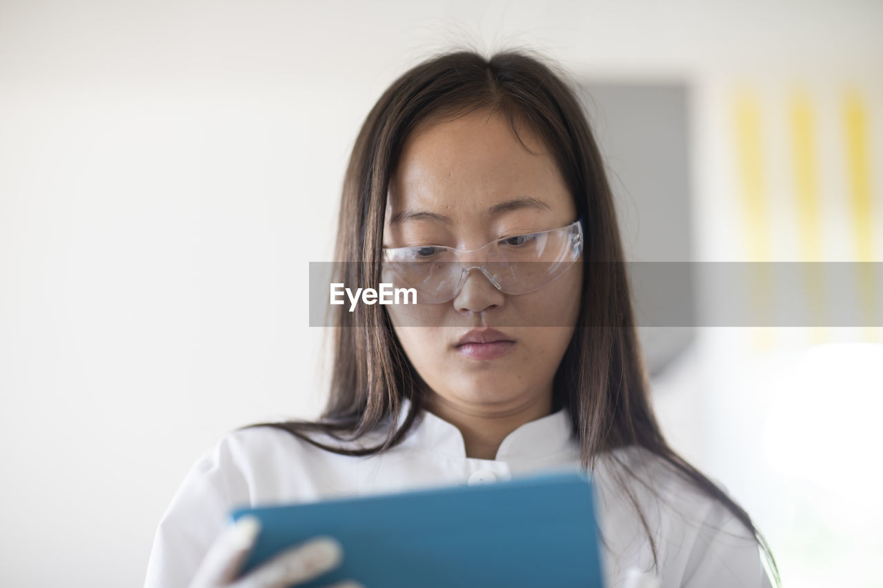 Scientist female with lab glasses and tablet in a lab